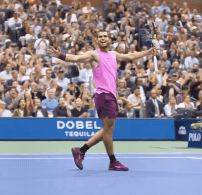 Man In Pink Tank Top Holding Tennis Racquet In Front Of Dobel Tequila Banner GIF