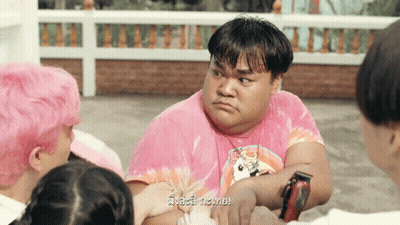 Man In Pink Tie Dye Shirt Surrounded By People GIF