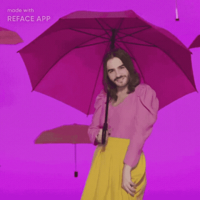 Man In Pink Top And Yellow Skirt Holding Pink Umbrella GIF