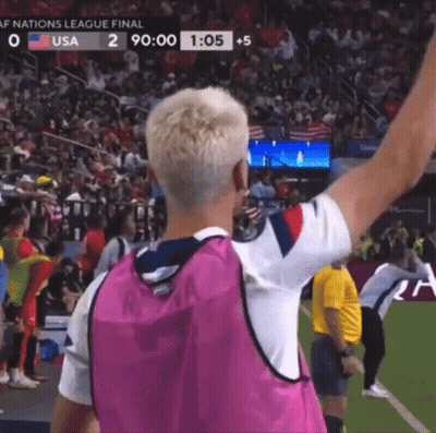 Man In Pink Vest Arm Raised On Soccer Field GIF