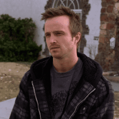 Man In Plaid Jacket And Gray Shirt Sitting Outside GIF