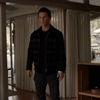 Man In Plaid Jacket Standing In Room With White Curtains GIF