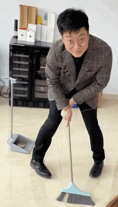 Man In Plaid Jacket Sweeping With Blue Broom GIF