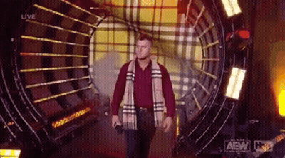 Man In Plaid Scarf And Red Shirt Walking Through Tunnel GIF