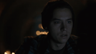 Man in Plaid Shirt and Beanie Looking at Camera in Dark