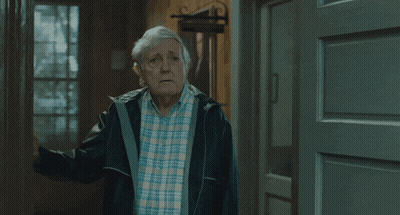 Man In Plaid Shirt And Black Jacket In Hallway GIF