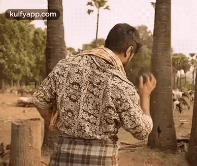 Man In Plaid Shirt And Lungi Standing In Field GIF