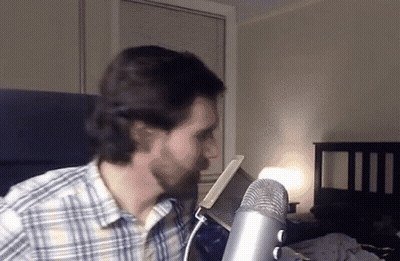 Man In Plaid Shirt At Microphone GIF