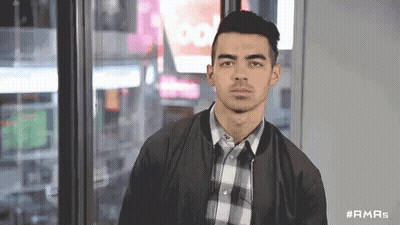 Man In Plaid Shirt At Window With Sign Saying Too GIF