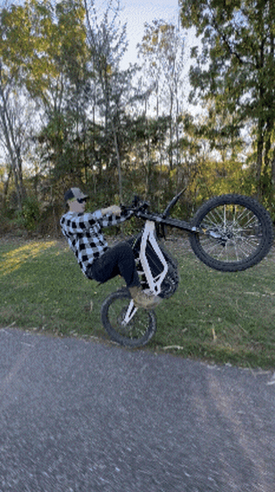 Man In Plaid Shirt Doing Bike Trick GIF