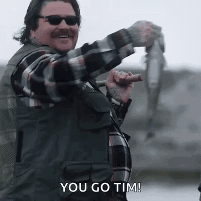 Man In Plaid Shirt Holding Fish And Fishing Rod GIF