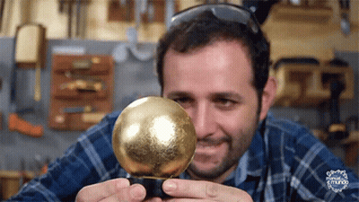 Man In Plaid Shirt Holding Gold Ball GIF