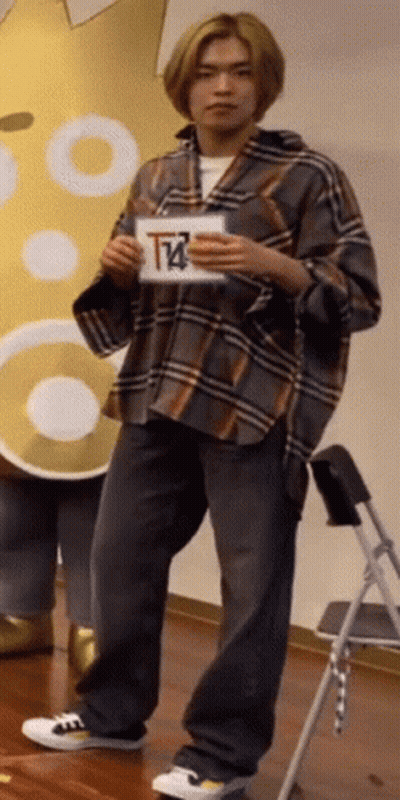 Man In Plaid Shirt Holding Sign With Letter T GIF
