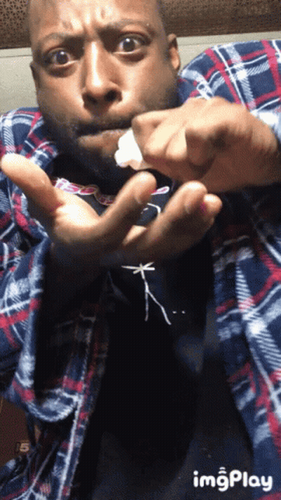 Man In Plaid Shirt Holding Something GIF