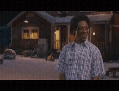 Man In Plaid Shirt In Front Of House At Night GIF