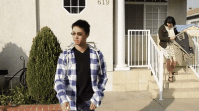 Man In Plaid Shirt In Front Of House Number 619 GIF