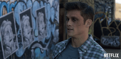 Man In Plaid Shirt In Front Of Netflix Graffiti GIF