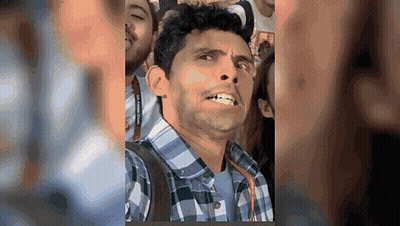Man In Plaid Shirt Making Funny Face In Crowd GIF