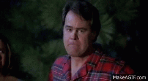Man In Plaid Shirt Making Funny Face In Front Of Woman GIF
