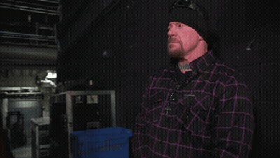 Man In Plaid Shirt Next To Man GIF