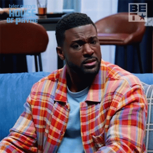 Man In Plaid Shirt On Blue Couch In Front Of House Of Payne GIF