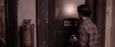 Man In Plaid Shirt Opening Restroom Door GIF