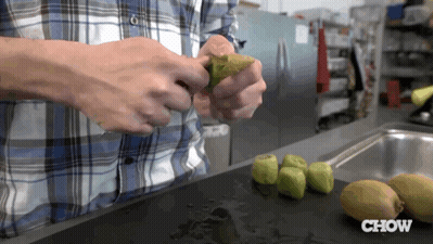 Man In Plaid Shirt Peeling Kiwi GIF