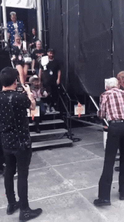 Man In Plaid Shirt Photographing Woman On Stairs GIF