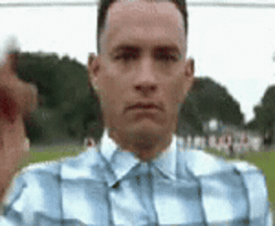 Man In Plaid Shirt Pointing At Camera In Field GIF