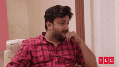 Man In Plaid Shirt Sitting On Couch With TLC Logo GIF