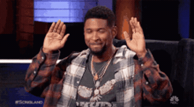 Man In Plaid Shirt Sitting With Hands Up GIF