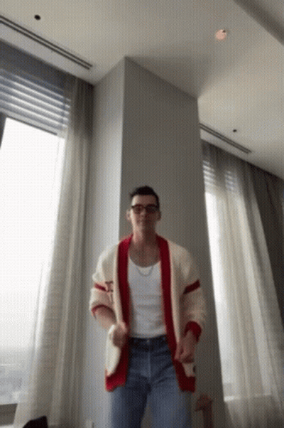 Man In Plaid Shirt Sitting With Hands Up GIF