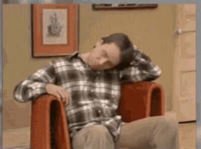 Man In Plaid Shirt Sitting With Head On Hands GIF