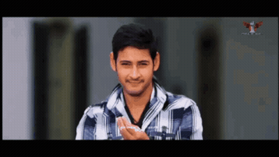 Man In Plaid Shirt Smiling In Front Of TV GIF