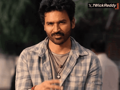 Man In Plaid Shirt Standing In Front Of X7wickreddy Banner GIF