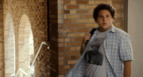 Man In Plaid Shirt Standing In Hallway GIF