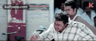Man In Plaid Shirt Standing Next To Another In Crowd GIF