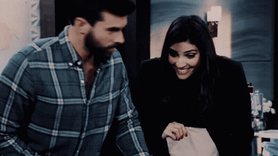 Man In Plaid Shirt Standing Next To Woman In Black Jacket GIF