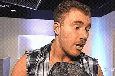 Man In Plaid Shirt Talking Into Microphone GIF