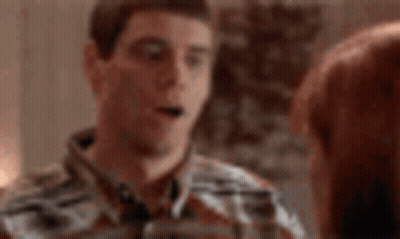 Man In Plaid Shirt Talking On Cell Phone Next To Woman GIF