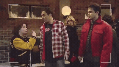 Man In Plaid Shirt Talking On Phone Woman In Yellow Jacket GIF