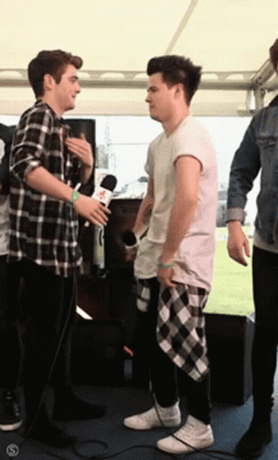 Man In Plaid Shirt Talking To Another Man GIF