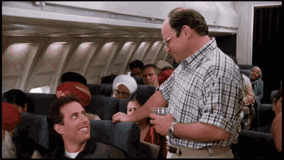 Man In Plaid Shirt Talking To Another Man On Plane GIF