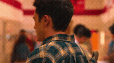 Man In Plaid Shirt Walking Hallway With Backpack GIF