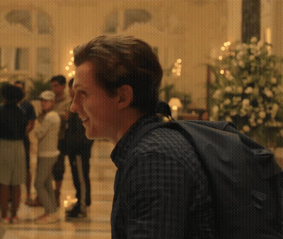 Man In Plaid Shirt With Black Backpack Smiling GIF