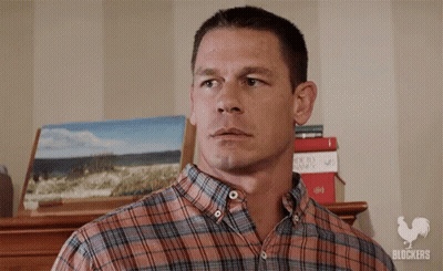 Man In Plaid Shirt With Stack Of Books And Painting GIF