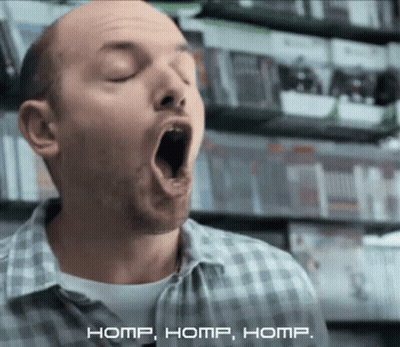 Man In Plaid Shirt Yawning By Video Game Shelf GIF
