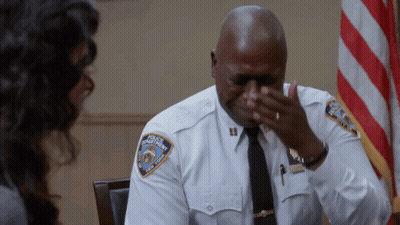 Man In Police Uniform Covering Face GIF