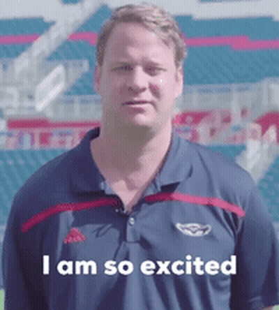 Man In Polo Shirt Says I Am So Excited In Front Of Stadium GIF