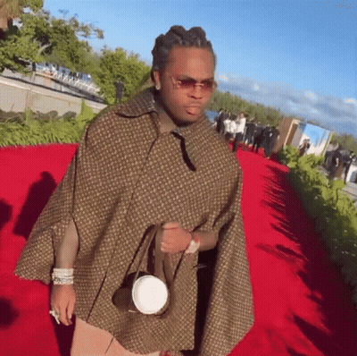 Man In Poncho And Sunglasses On Red Carpet GIF
